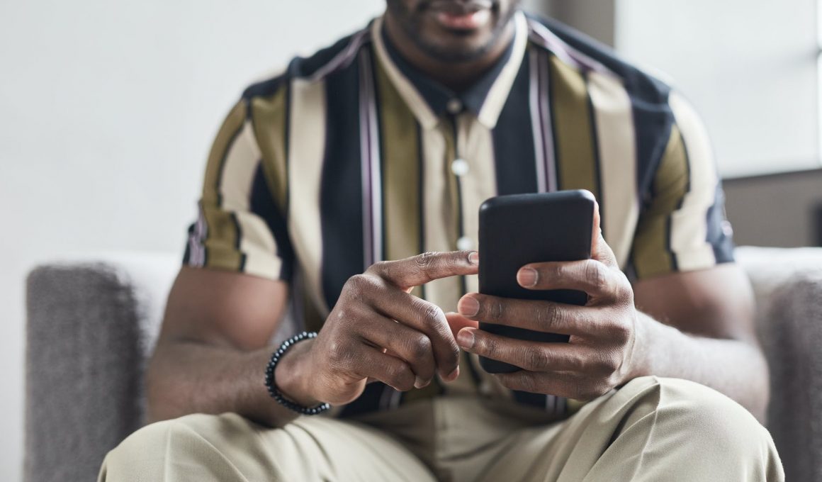 a man in striped shirt using his mobile phone