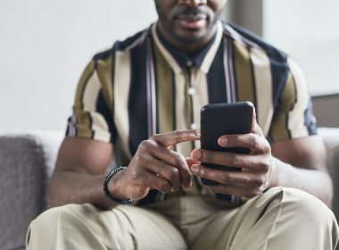 a man in striped shirt using his mobile phone