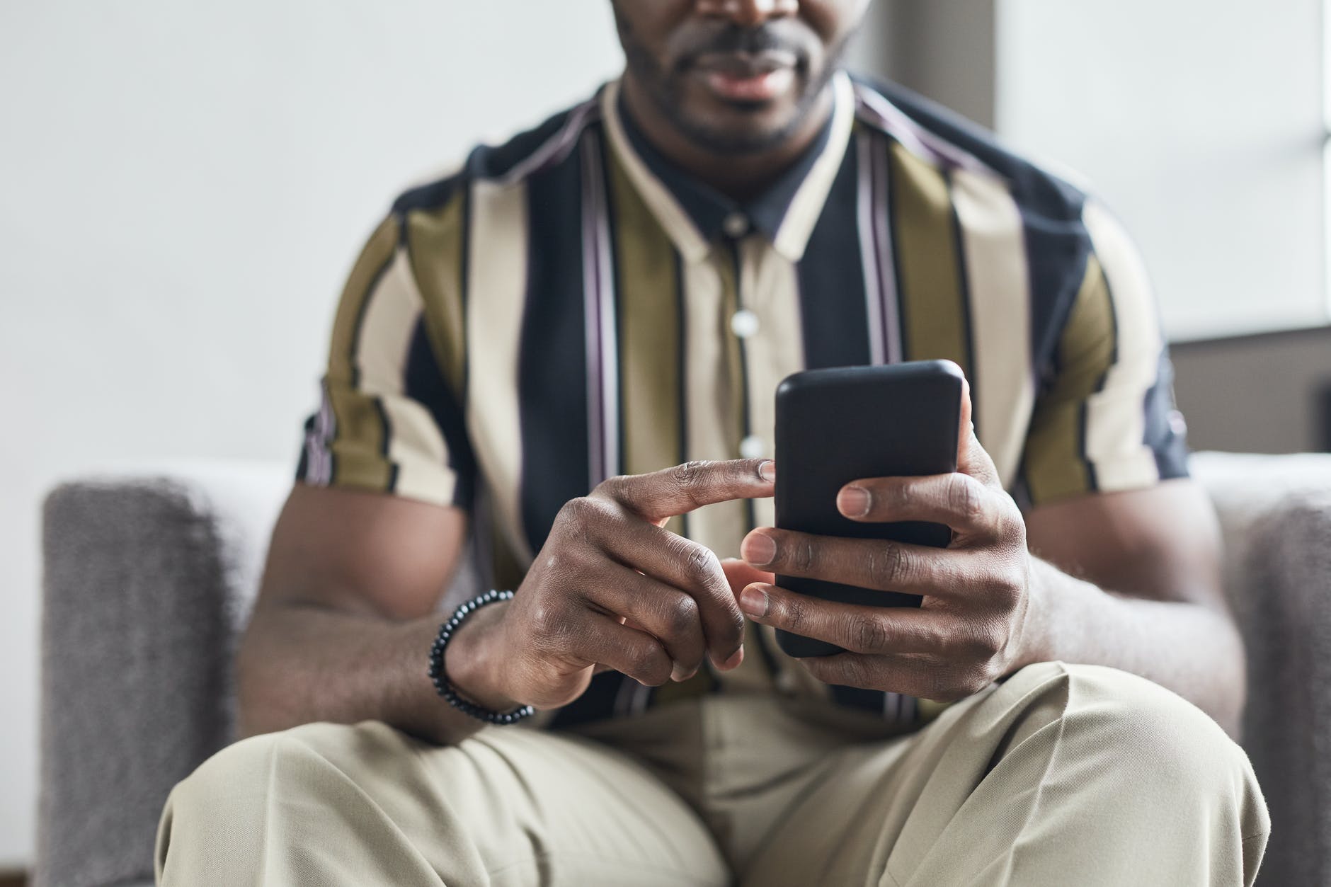 a man in striped shirt using his mobile phone